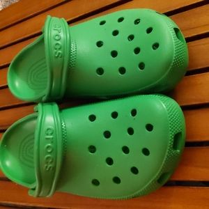 BRAND NEW GREEN CROCS! Right shoe has 5 small cat claw holes.